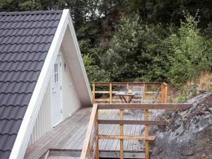 una terraza de madera con mesa y un edificio en A lovely bright apartment with it's own entrance, en Kungsbacka