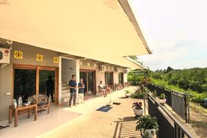 people standing on the balcony of a building at Hotel Bonne Nuit in Labuan Bajo