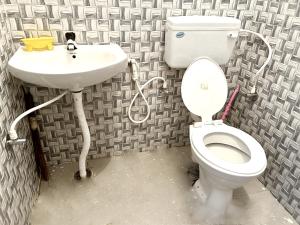 a bathroom with a toilet and a sink at MDY Studio Room - Mysore in Mysore