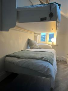 a small bed in a room with a window at Stunningly stylish cottage. in Bradwell