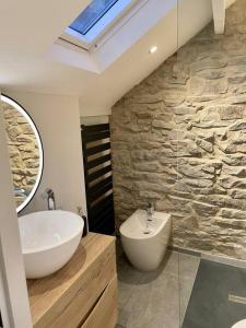 a bathroom with a sink and a tub and a mirror at Stunningly stylish cottage. in Bradwell +42 photos