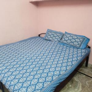 uma cama com lençóis e almofadas azuis e brancos em Bhavyam HomeStay &Cafe BackPackers ko em Bundi