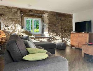 a living room with a couch and a tv at Stunningly stylish cottage. in Bradwell