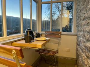 a room with a table and chairs and windows at Stunningly stylish cottage. in Bradwell