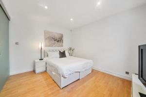 a white bedroom with a bed and a television at GRANGE City 2 Bed Modern Apartment by Tower Bridge London Bridge in London