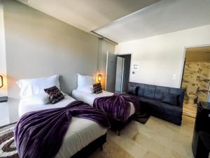 pokój hotelowy z 2 łóżkami i kanapą w obiekcie CENTRAL VIEW ΜΙΔΕΙΑ w mieście Liwadia