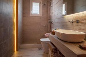 a bathroom with a sink and a shower and a toilet at Eleni's Guesthouse in Apróvaton