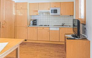 uma cozinha com armários de madeira e uma televisão num balcão em 1 Bedroom Gorgeous Apartment In Ischgl em Ischgl