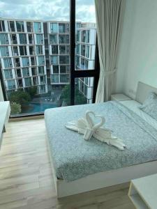 uma cama num quarto com uma grande janela em Luxury condo in phuket shopping center em Phuket