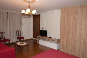 ein Wohnzimmer mit einem roten Sofa und einem TV in der Unterkunft VILLA MARIA in Altopascio