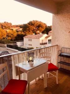 a white table and chairs on a balcony with a view at 2min mer Studio Parking Balcon Wifi Clim in Six-Fours-les-Plages