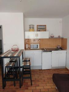 a kitchen with white cabinets and a table and chairs at 2min mer Studio Parking Balcon Wifi Clim in Six-Fours-les-Plages