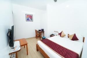 a hotel room with a bed and a tv at Pearl bell Villa in Puducherry