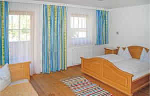 ツェル・アム・ツィラーにあるBeautiful Apartment In Hainzenberg With 2 Bedroomsのベッドルーム1室(木製ベッド1台、窓2つ付)