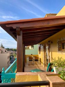 a patio with a wooden roof with a table at Apartamentos San Jose in Valle Gran Rey