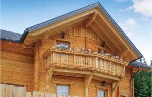 eine Blockhütte mit einem Balkon mit Blumen darauf in der Unterkunft Amazing Home In Schnberg Lachtal With Sauna in Lachtal