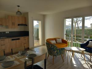 Una cocina y una sala de estar con mesa y sillas. en Appartement 2 chambres proche Grande Plage, en Saint Gilles Croix de vie