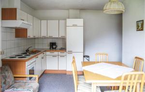 a kitchen with a table and a white refrigerator at 2 Bedroom Awesome Apartment In Kappl in Kappl