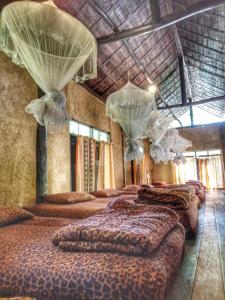 um quarto com quatro camas com cortinas e redes em ห้องนอนรวม em Ban Tham