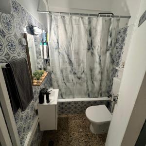 La salle de bains est pourvue d'un rideau de douche et de toilettes. dans l'établissement Cardia’s Guest House, à Sacavém