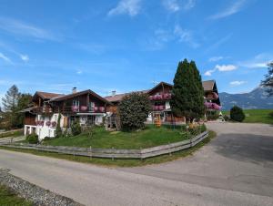 ein Haus auf einem Hügel mit Auffahrt in der Unterkunft Ferienwohnung Stuimändle in Obermaiselstein