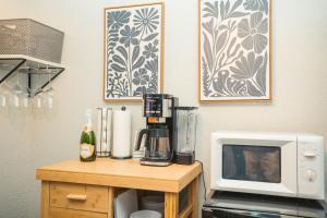 Windsor Retreat Private Basement Suite في دنفر: مطبخ مع ميكروويف وصانع قهوة على طاولة