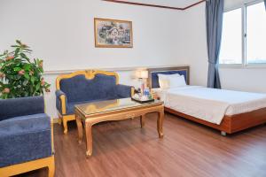 a hotel room with a bed and a couch and a table at A25 Premium Hotel - 12 Ngô Sỹ Liên in Hanoi