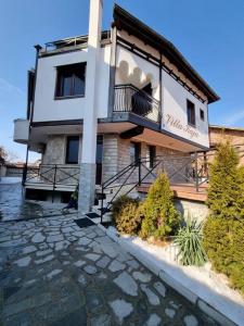 班斯科的住宿－Villa Kaja Bansko，带阳台和石头走道的建筑