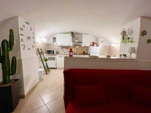 kuchnia z czerwoną kanapą w pokoju w obiekcie Ursino holiday apartment w Katanii