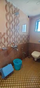 bagno con servizi igienici e secchio blu di Maple Villa a Mahabaleshwar
