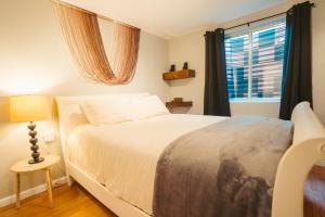 a bedroom with a white bed and a window at Windsor Retreat Private Basement Suite in Denver