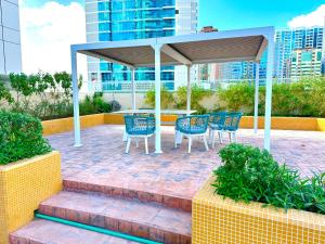 a patio with blue chairs and a gazebo at Luxury Apartment Al Khan Corniche View 2 BD in Sharjah