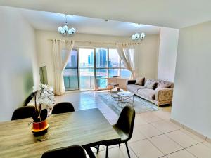een woonkamer met een tafel en een bank bij Luxury Apartment Al Khan Corniche View 2 BD in Sharjah