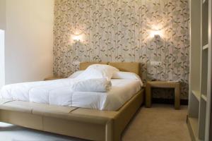 a bedroom with a bed with two lamps on the wall at Hotel Teratermal in Valdeavellano de Tera