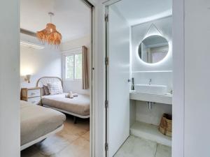 y baño con cama, lavabo y espejo. en Cosy 4 bedroom house with private terrace, en Hospitalet de Llobregat
