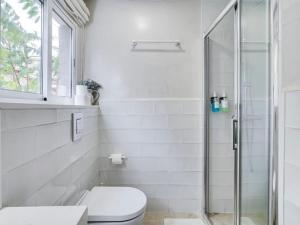 a white bathroom with a toilet and a shower at Cosy 4 bedroom house with private terrace in Hospitalet de Llobregat