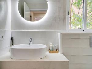 Baño blanco con lavabo y espejo en Cosy 4 bedroom house with private terrace en Hospitalet de Llobregat