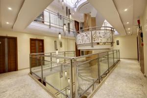 una escalera en un edificio con barandilla de cristal en Hotel Shanti Plaza-by Haveliya Hotels en Nueva Delhi