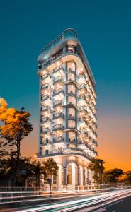 a tall white building in front of a street at RHM Luxury Hotel And Suite in Danang