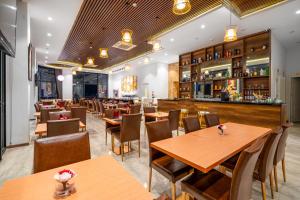 a restaurant with wooden tables and chairs and a bar at RHM Luxury Hotel And Suite in Danang