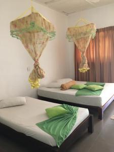 two twin beds in a room with curtains at Polonnaruwa Holiday Inn in Polonnaruwa