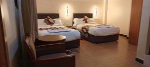 ein Hotelzimmer mit 2 Betten und einem Stuhl in der Unterkunft Hotel 21 in Aksum