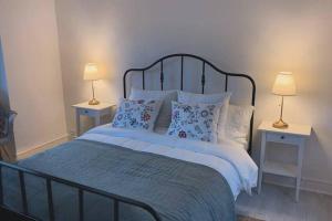 ein Schlafzimmer mit einem Bett mit Kissen und zwei Lampen in der Unterkunft Le Petit Bourdieu - Chevreuil in Jurançon