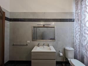 uma casa de banho com um lavatório, um WC e um espelho. em Tra Monti e Mare em La Spezia