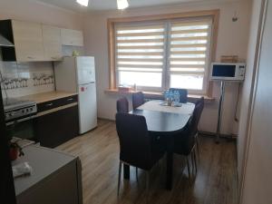 a kitchen with a table and chairs in a room at Apartament przy puszczy in Hajnówka