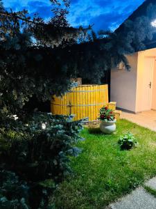 einen Hof mit einem gelben Zaun und einer Bank in der Unterkunft Evie's Tree House in Dragomirna