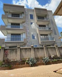 a tall building with a fence in front of it at Cozy Oasis in Kampala