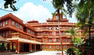 a large red building with a clock tower at Krishna Beach Resort in Kannur