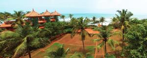 an aerial view of a resort with palm trees and the ocean at Krishna Beach Resort in Kannur