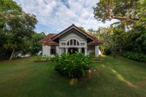 a small white house with a green yard at MO River House Luxury Villa in Hikkaduwa